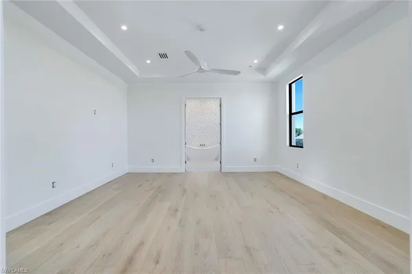 an empty room with wooden floor and window