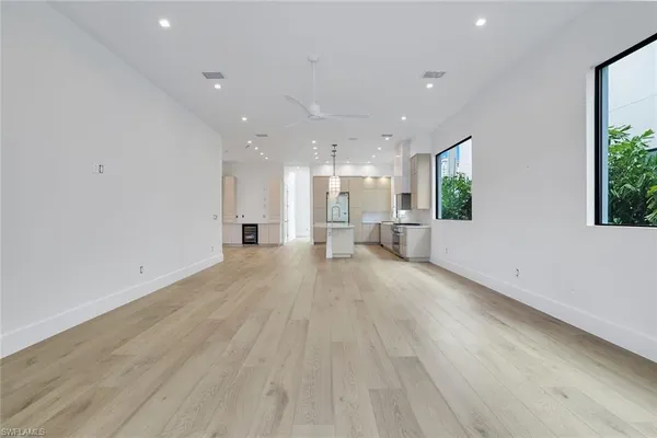 a view of a big room with wooden floor and windows