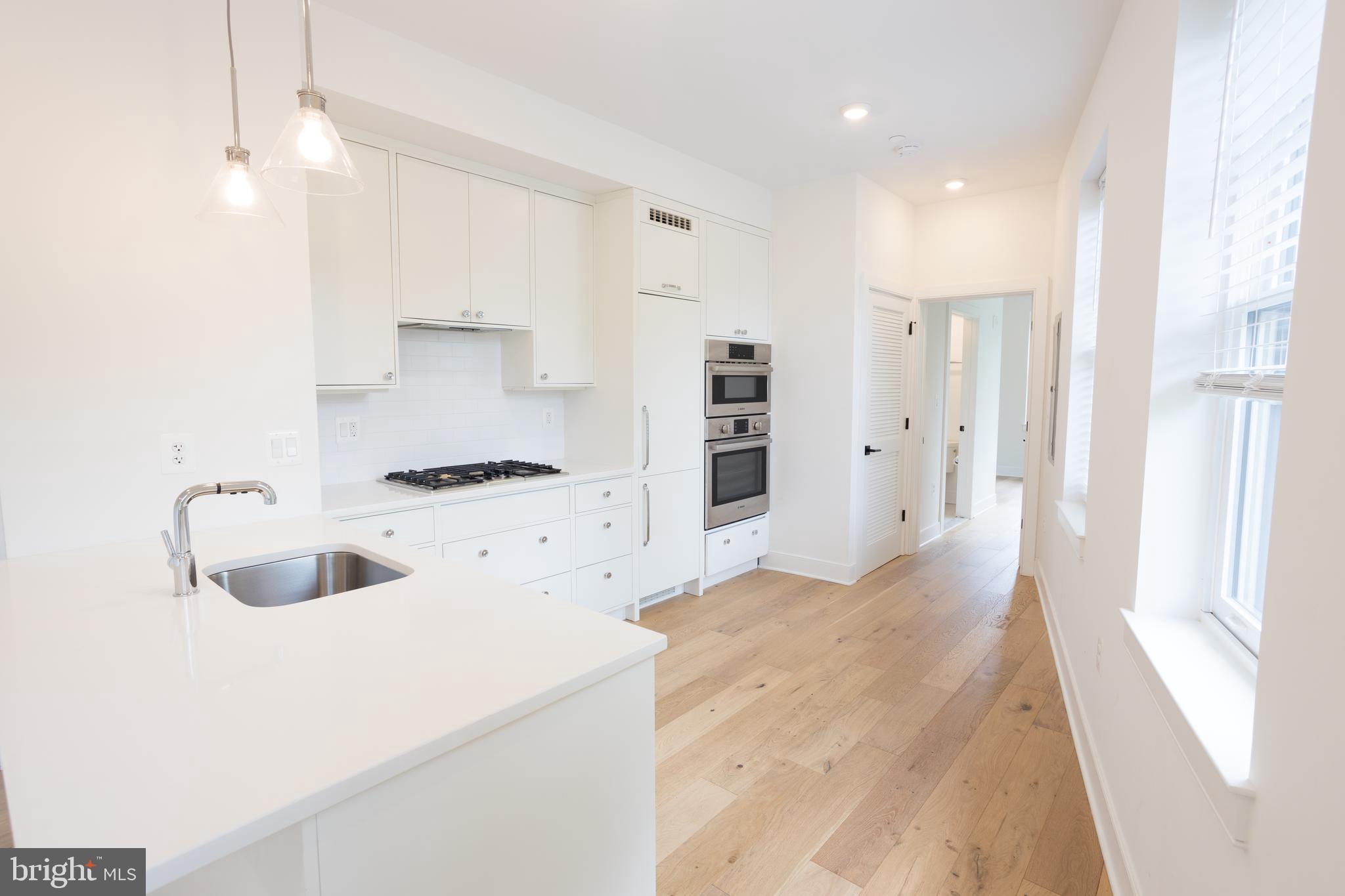 2869 28th Street Northwest, Unit 1 Washington, DC 20008 - Photo 10 of 19 a kitchen with stainless steel appliances kitchen island a refrigerator sink and cabinets