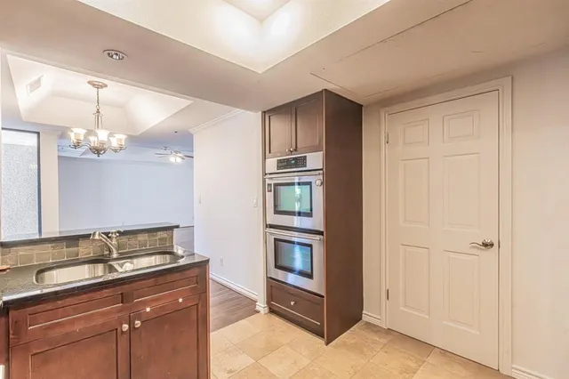 an empty room with a chandelier fan and closet area