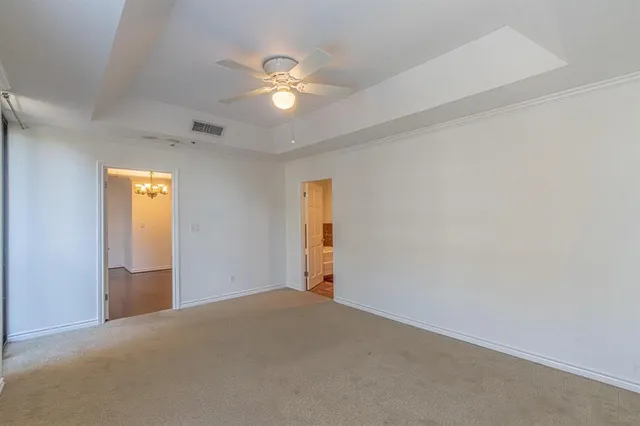 an empty room with a chandelier fan