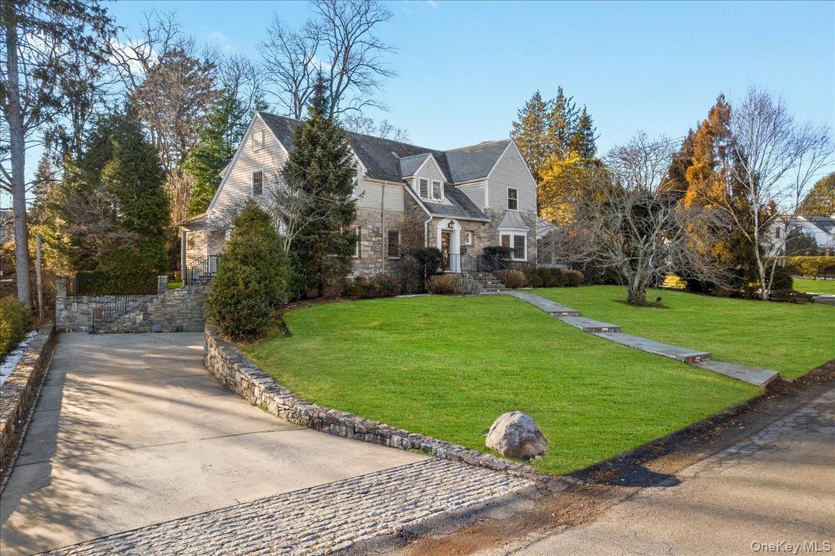 New England style home nicely elevated and set back featuring stone and cedar wood shingles