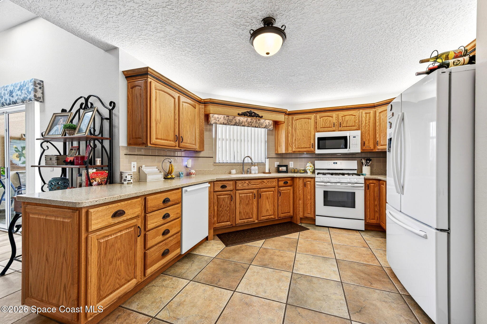 3969 Ridgewood Drive Titusville, FL 32796 - Photo 13 of 34 a kitchen with stainless steel appliances a stove sink and cabinets