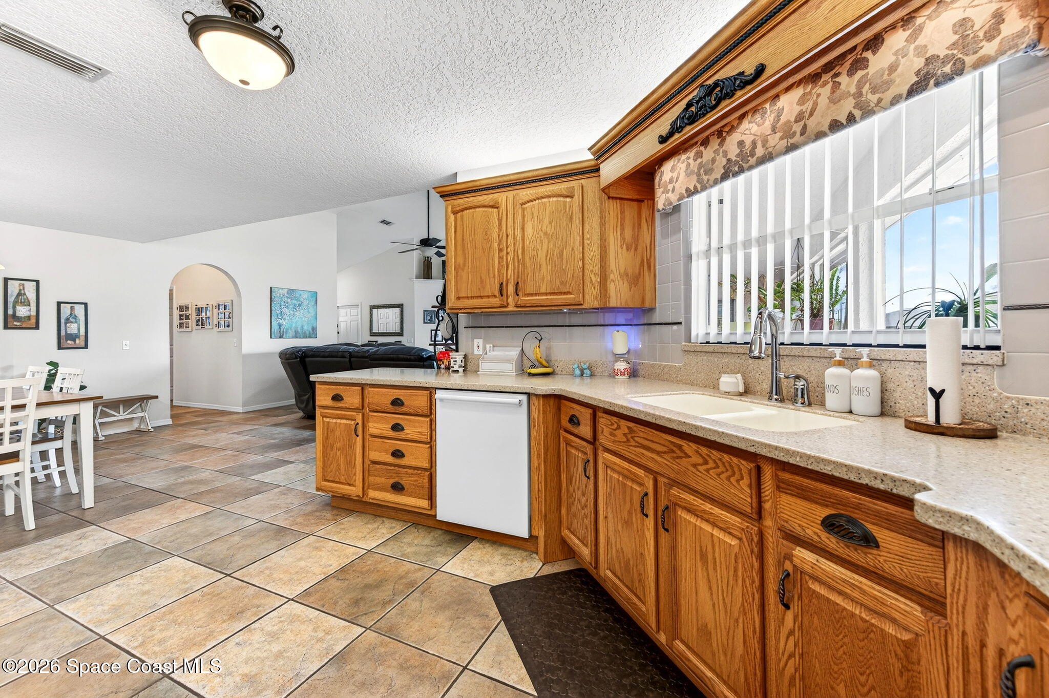 3969 Ridgewood Drive Titusville, FL 32796 - Photo 15 of 34 a kitchen with kitchen island granite countertop a sink cabinets and window