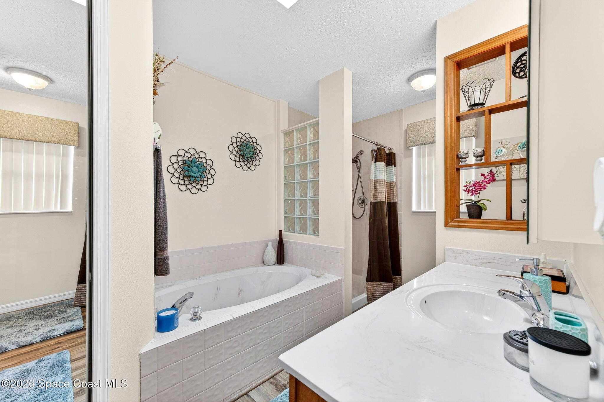 3969 Ridgewood Drive Titusville, FL 32796 - Photo 23 of 34 a bathroom with a tub a sink and a shower