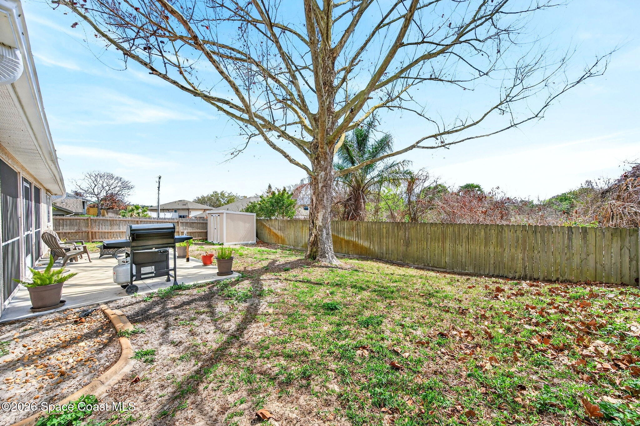 3969 Ridgewood Drive Titusville, FL 32796 - Photo 31 of 34 a backyard of a house with table and chairs