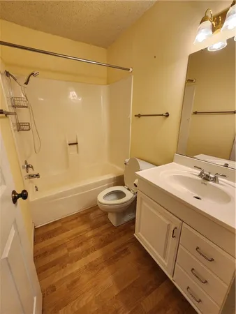a bathroom with a granite countertop sink a toilet and shower