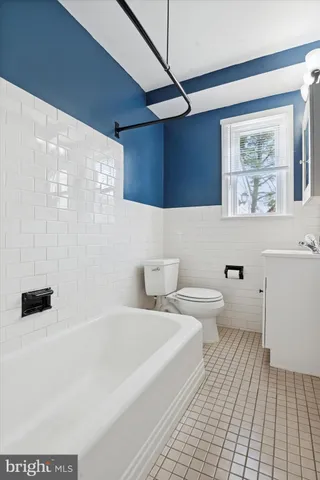 a bathroom with a toilet a sink a mirror and bathtub