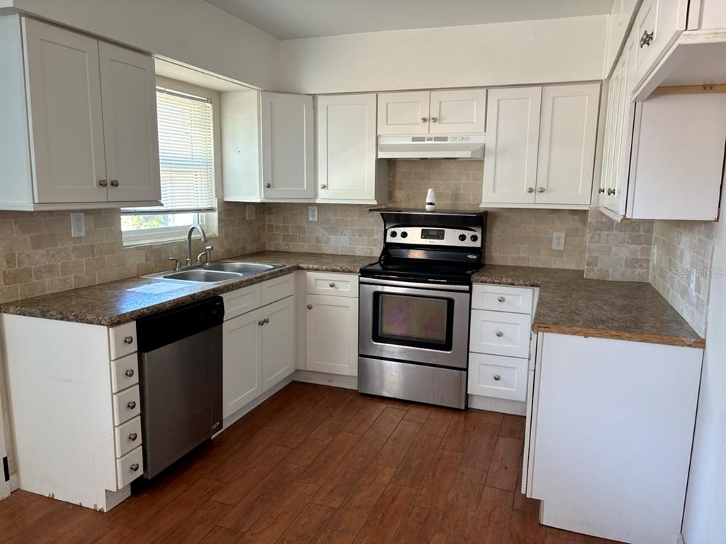 264 14th Street Northwest Largo, FL 33770 - Photo 4 of 12 a kitchen with granite countertop white cabinets and white appliances
