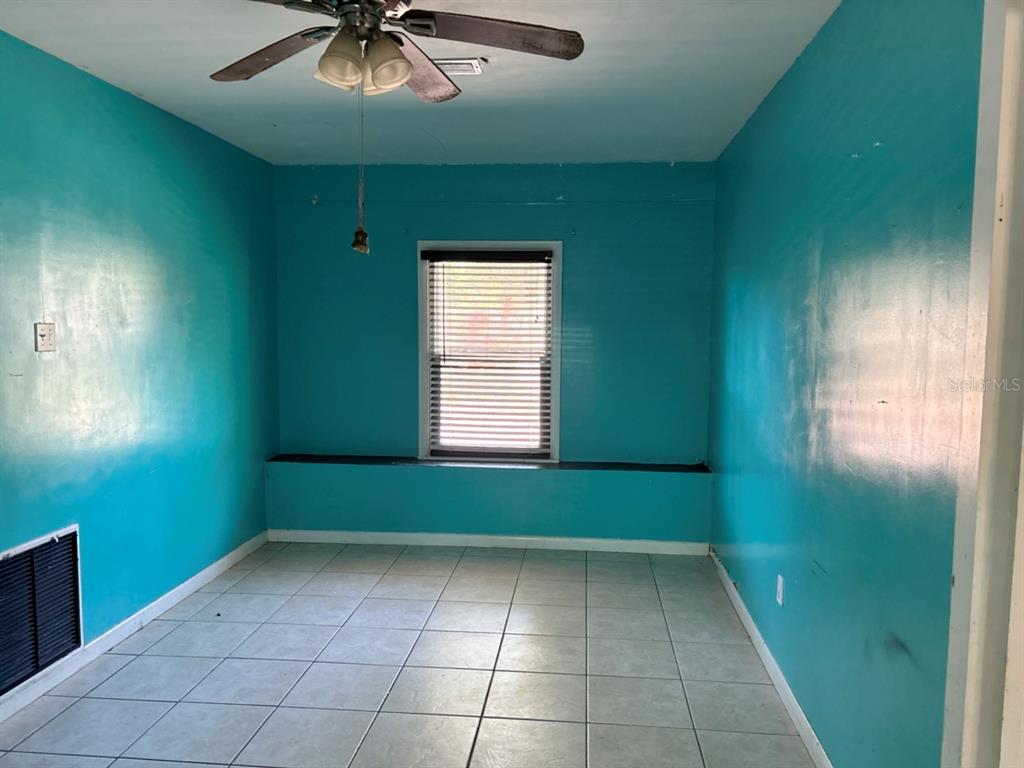 264 14th Street Northwest Largo, FL 33770 - Photo 6 of 12 an empty room with a window and a chandelier fan