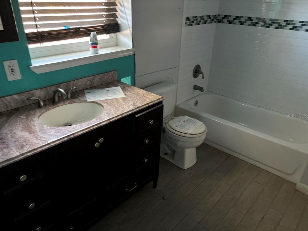 264 14th Street Northwest Largo, FL 33770 - Photo 7 of 12 a bathroom with a granite countertop sink toilet and shower