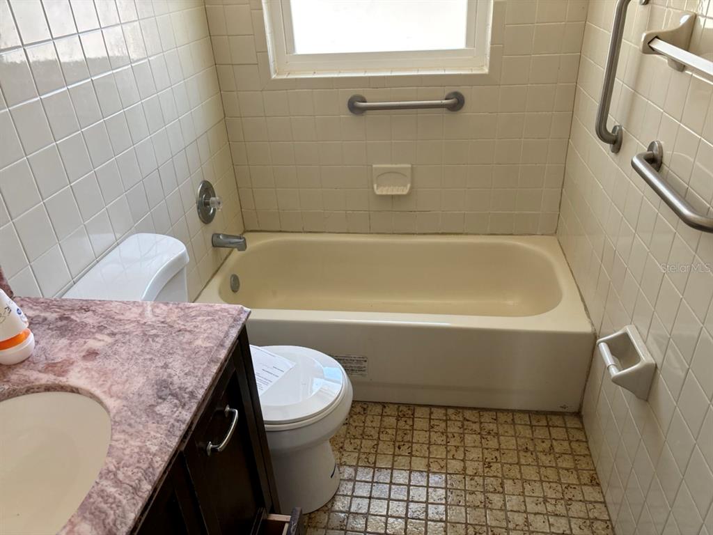 264 14th Street Northwest Largo, FL 33770 - Photo 8 of 12 a bathroom with a granite countertop bathtub sink vanity mirror and toilet