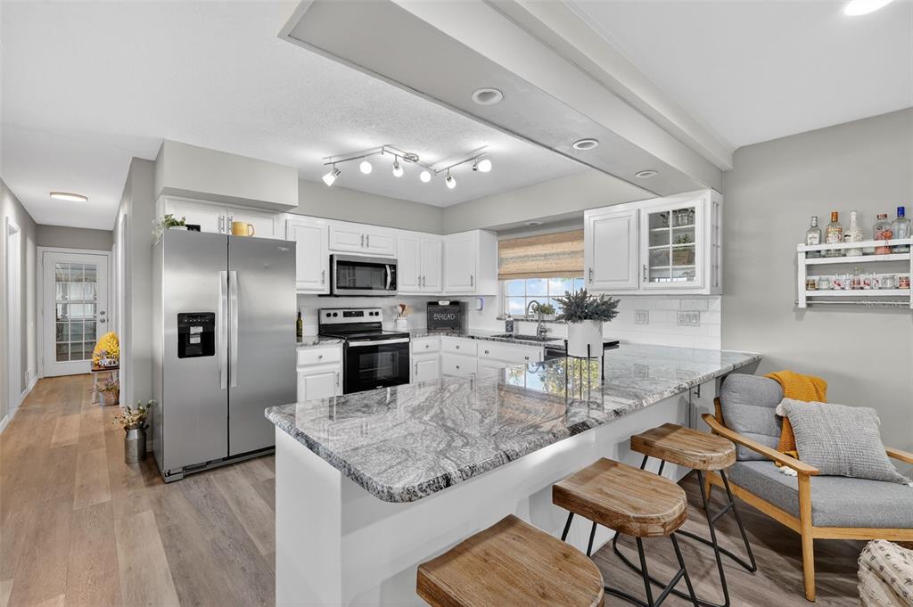 1101 Country Club Road Eustis, FL 32726 - Photo 14 of 44 a kitchen with stainless steel appliances granite countertop a stove refrigerator and cabinets