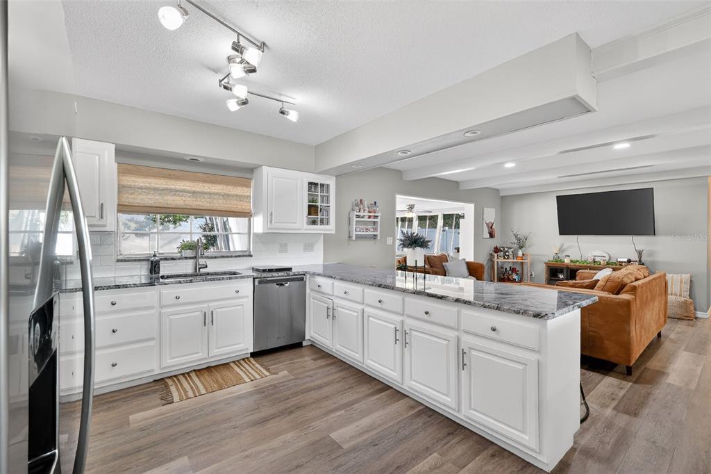 1101 Country Club Road Eustis, FL 32726 - Photo 16 of 44 a kitchen with sink cabinets and wooden floor
