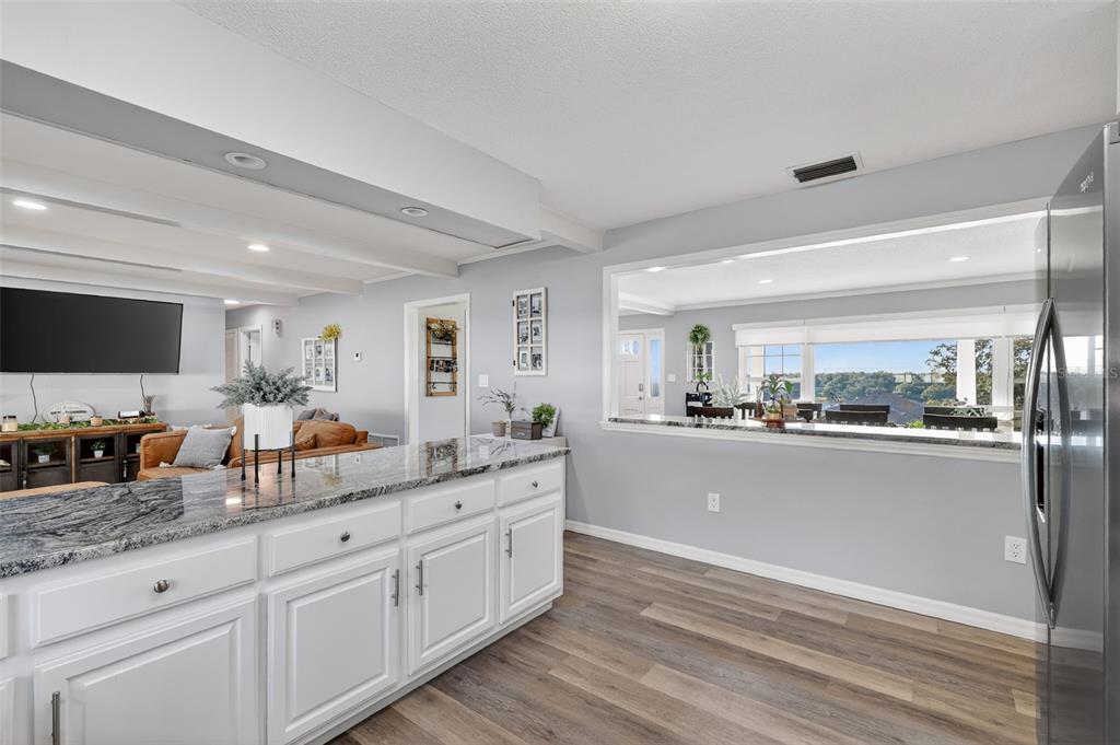 1101 Country Club Road Eustis, FL 32726 - Photo 17 of 44 a kitchen with granite countertop white cabinets and stainless steel appliances