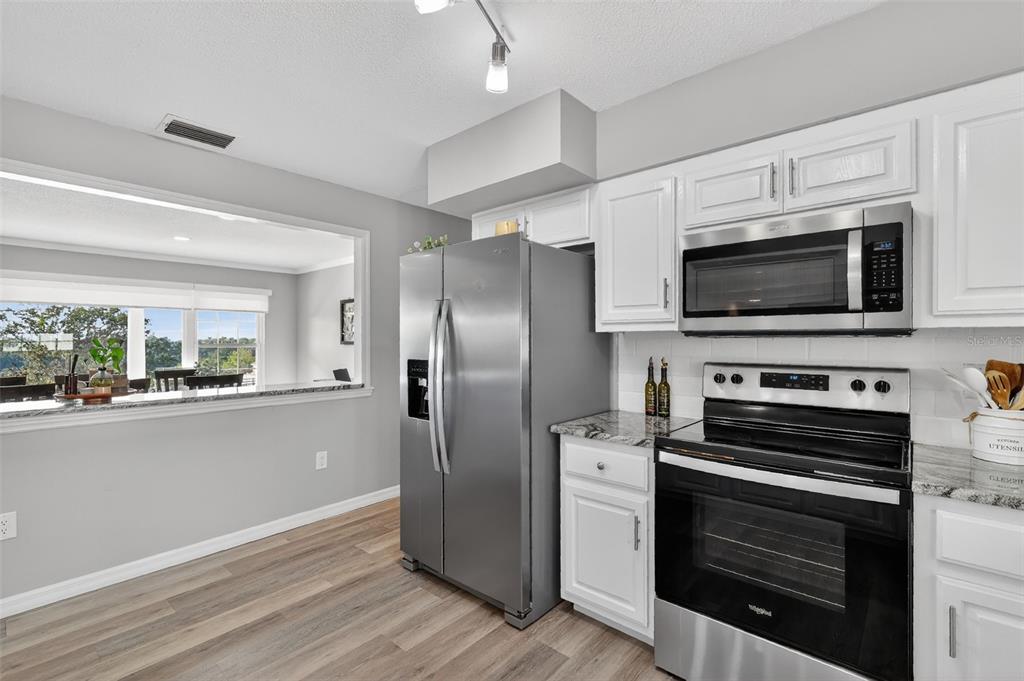 1101 Country Club Road Eustis, FL 32726 - Photo 18 of 44 a kitchen with stainless steel appliances a stove microwave and refrigerator