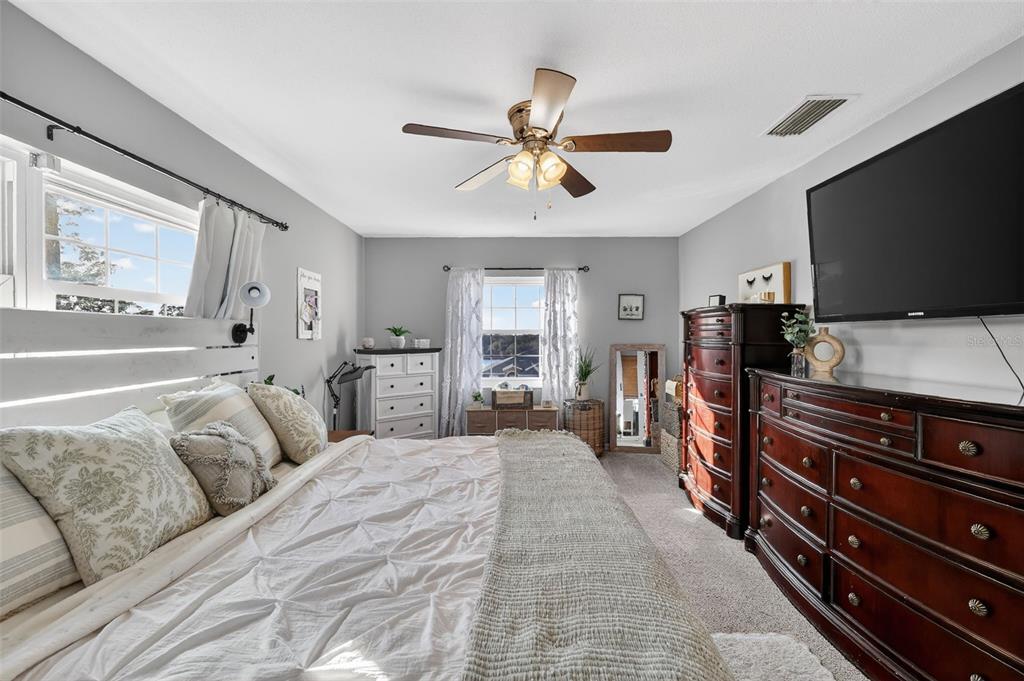 1101 Country Club Road Eustis, FL 32726 - Photo 20 of 44 a spacious bedroom with a bed and a flat screen tv