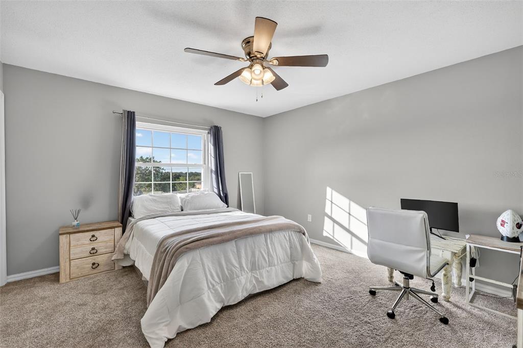 1101 Country Club Road Eustis, FL 32726 - Photo 24 of 44 a bedroom with a bed and a chandelier