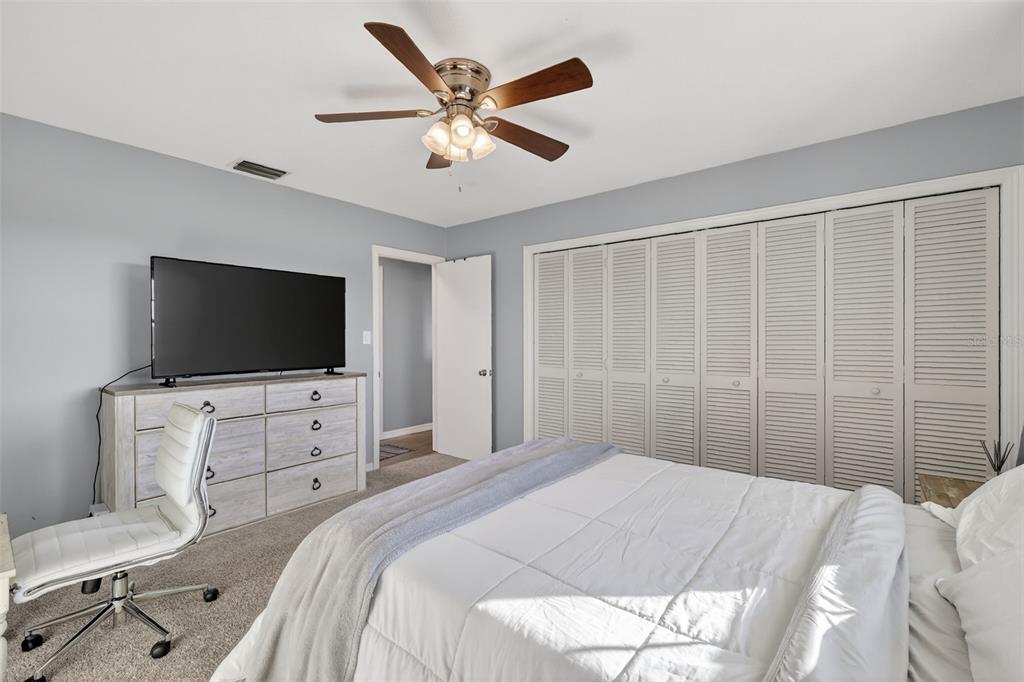 1101 Country Club Road Eustis, FL 32726 - Photo 25 of 44 a bedroom with a large bed and a flat screen tv