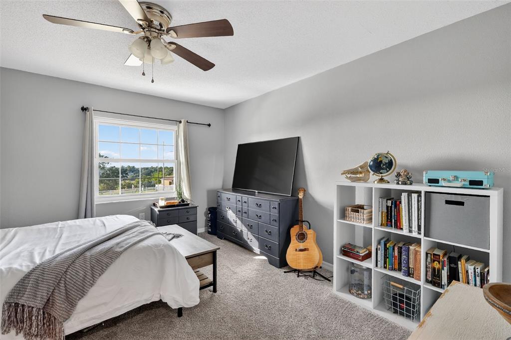 1101 Country Club Road Eustis, FL 32726 - Photo 27 of 44 a bedroom with a bed a book shelf and a window