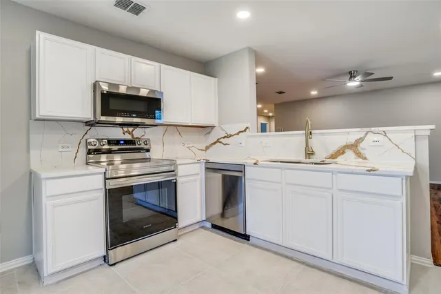 a kitchen with white cabinets stainless steel appliances and sink