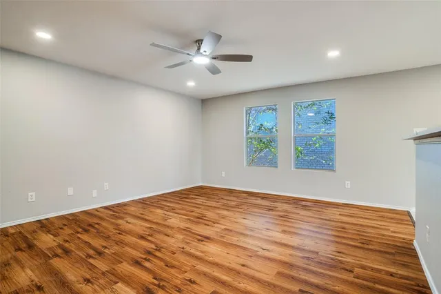 an empty room with windows and fan