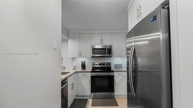 a kitchen with a refrigerator and a stove top oven