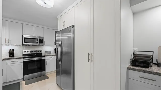 a kitchen with stainless steel appliances granite countertop a refrigerator and a stove top oven