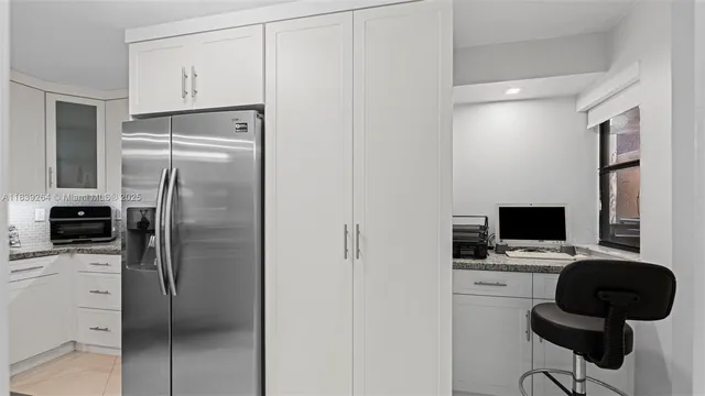 a metallic refrigerator freezer sitting in a kitchen