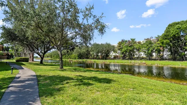 a view of a lake with a big yard and large trees