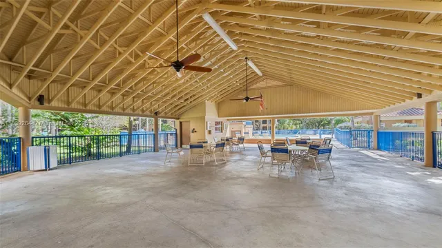 a view of a patio with table and chairs with wooden floor and fence