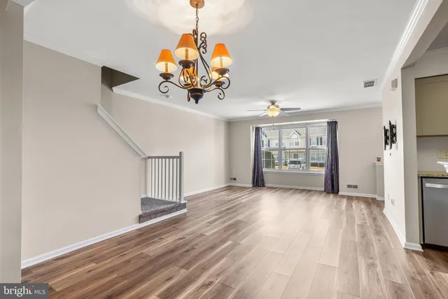 a view of a room with wooden floor ceiling fan and window