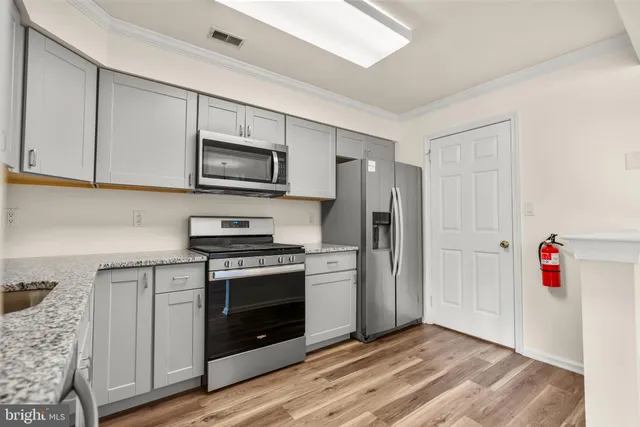 a kitchen with stainless steel appliances granite countertop a stove microwave and refrigerator