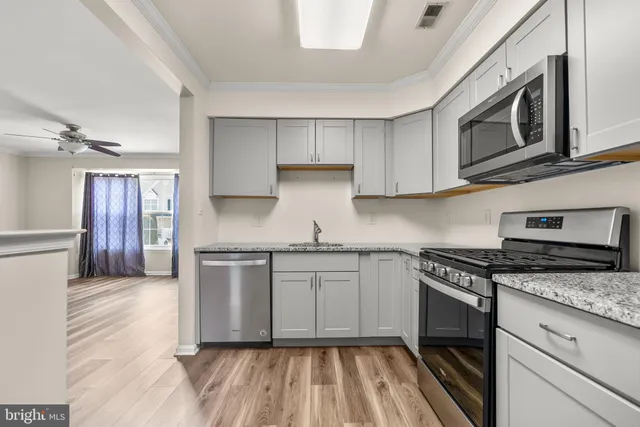 a kitchen with stainless steel appliances granite countertop a stove a sink and a microwave