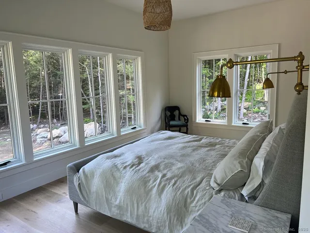 a bedroom with a bed and a large window