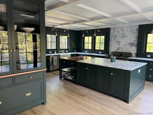 a kitchen with granite countertop a sink stove and cabinets