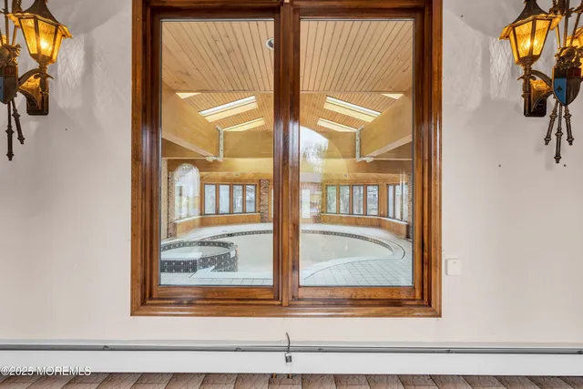 a view of a hallway with windows and chandelier