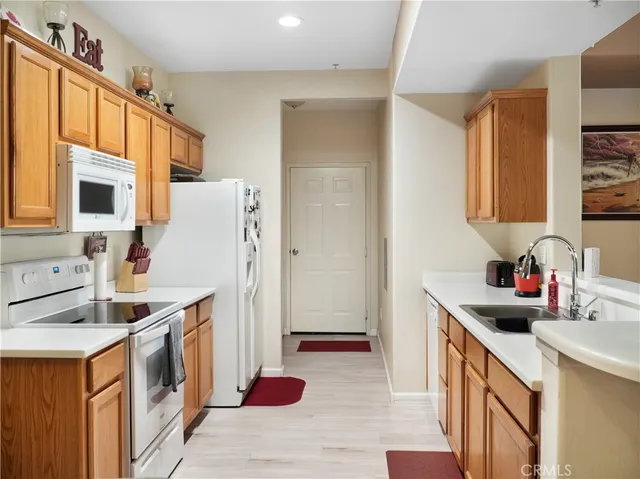 a kitchen with a sink a stove a refrigerator a washer dryer and cabinets