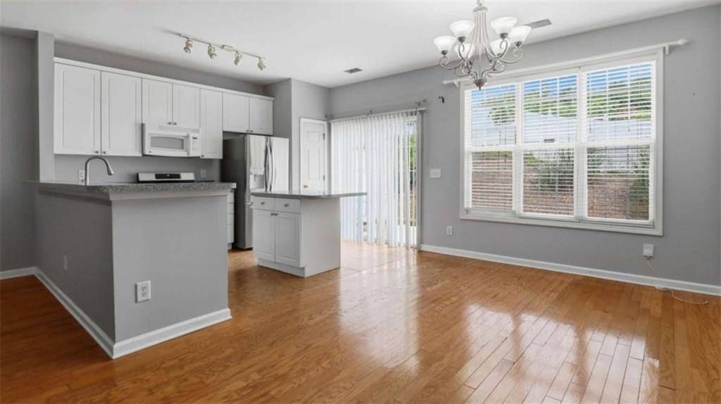 3522 Spring View Court Alpharetta, GA 30004 - Photo 3 of 25 a kitchen with stainless steel appliances granite countertop a refrigerator a stove oven a sink dishwasher and white cabinets with wooden floor