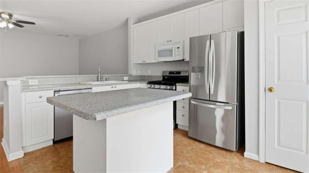 3522 Spring View Court Alpharetta, GA 30004 - Photo 5 of 25 a kitchen with a sink a refrigerator and white cabinets
