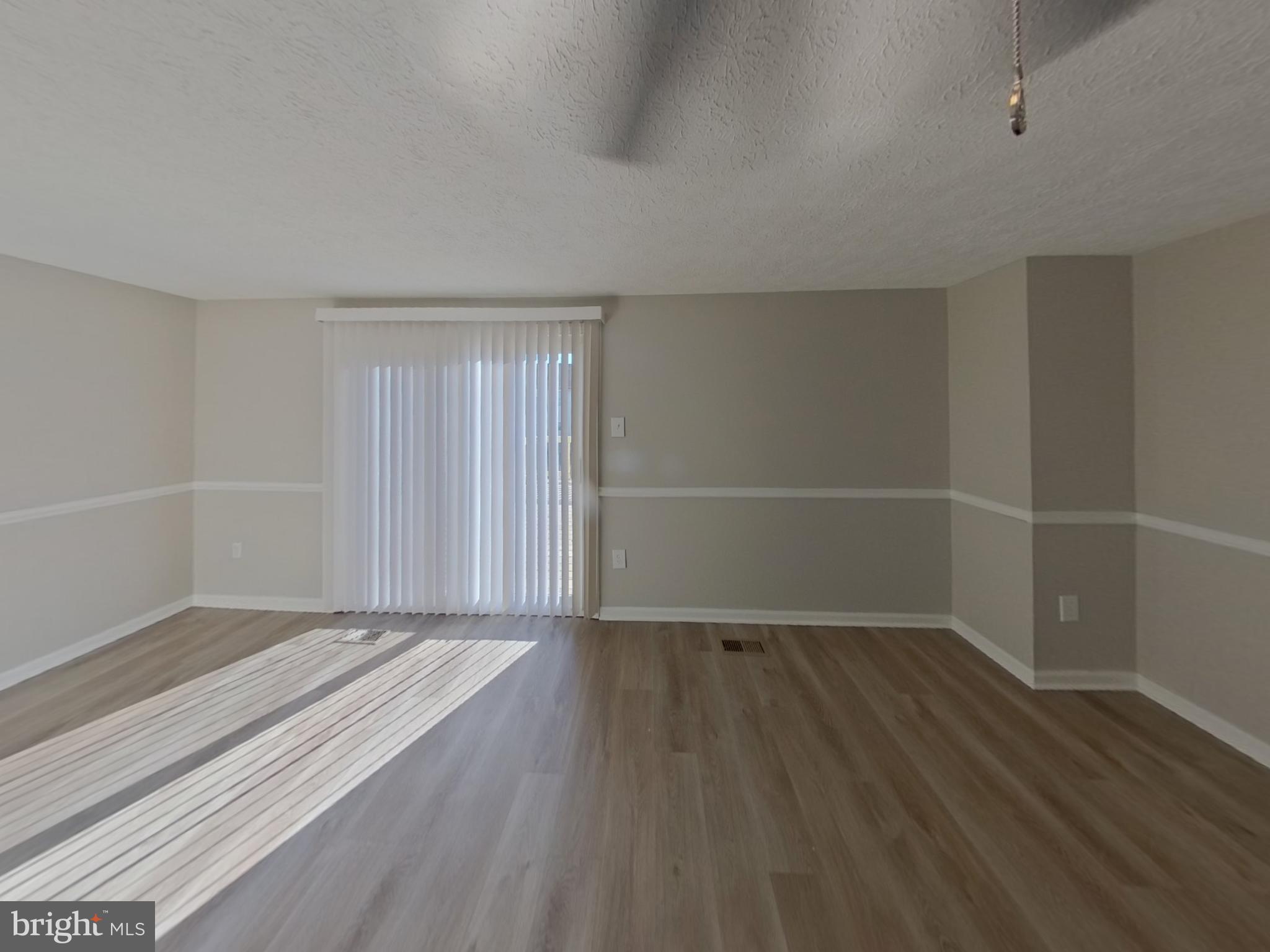 3776 Timahoe Circle Baltimore, MD 21236 - Photo 3 of 16 an empty room with wooden floor and windows