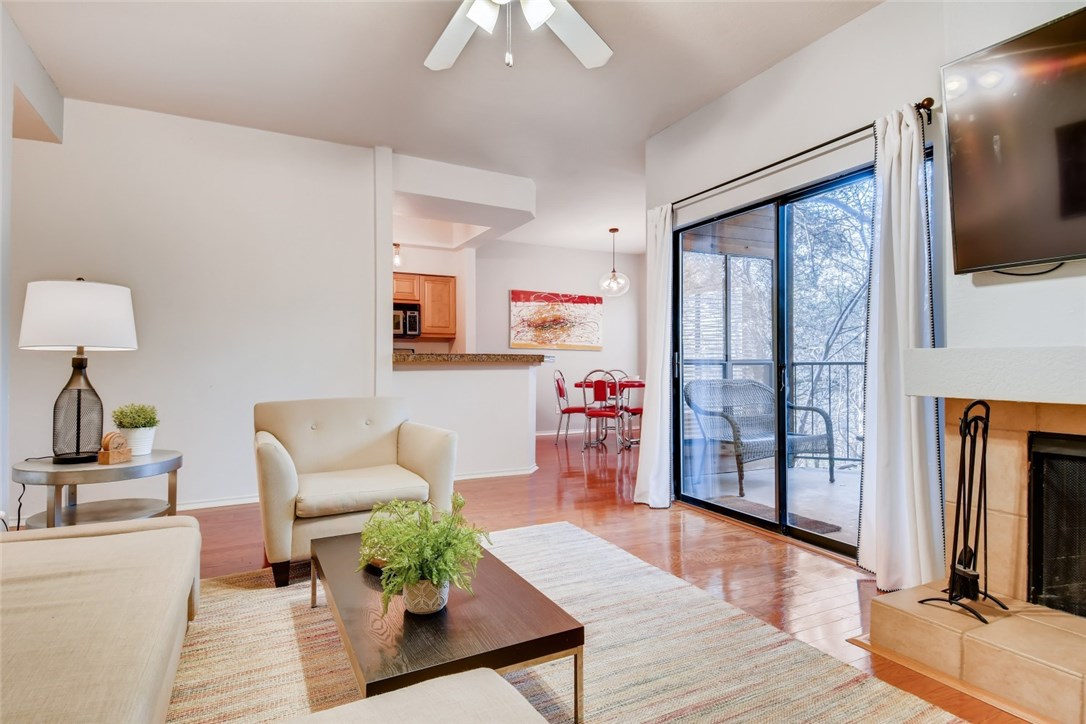 4711 Spicewood Springs Road, Unit 157 Austin, TX 78759 - Photo 1 of 1 a living room with furniture a flat screen tv and a floor to ceiling window