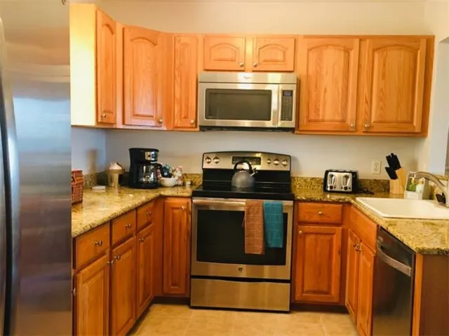 a kitchen with stainless steel appliances granite countertop a sink stove and microwave