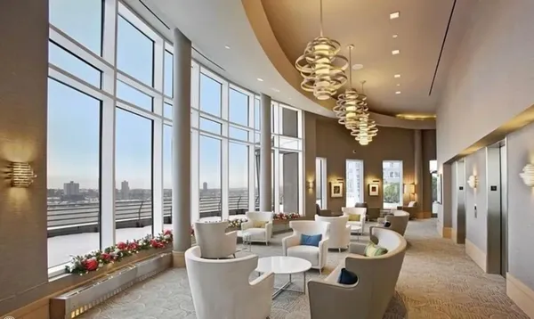 a very nice looking dining room with furniture chandelier and a large window