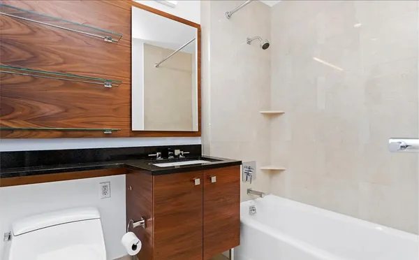 a bathroom with a granite countertop sink a toilet and bathtub