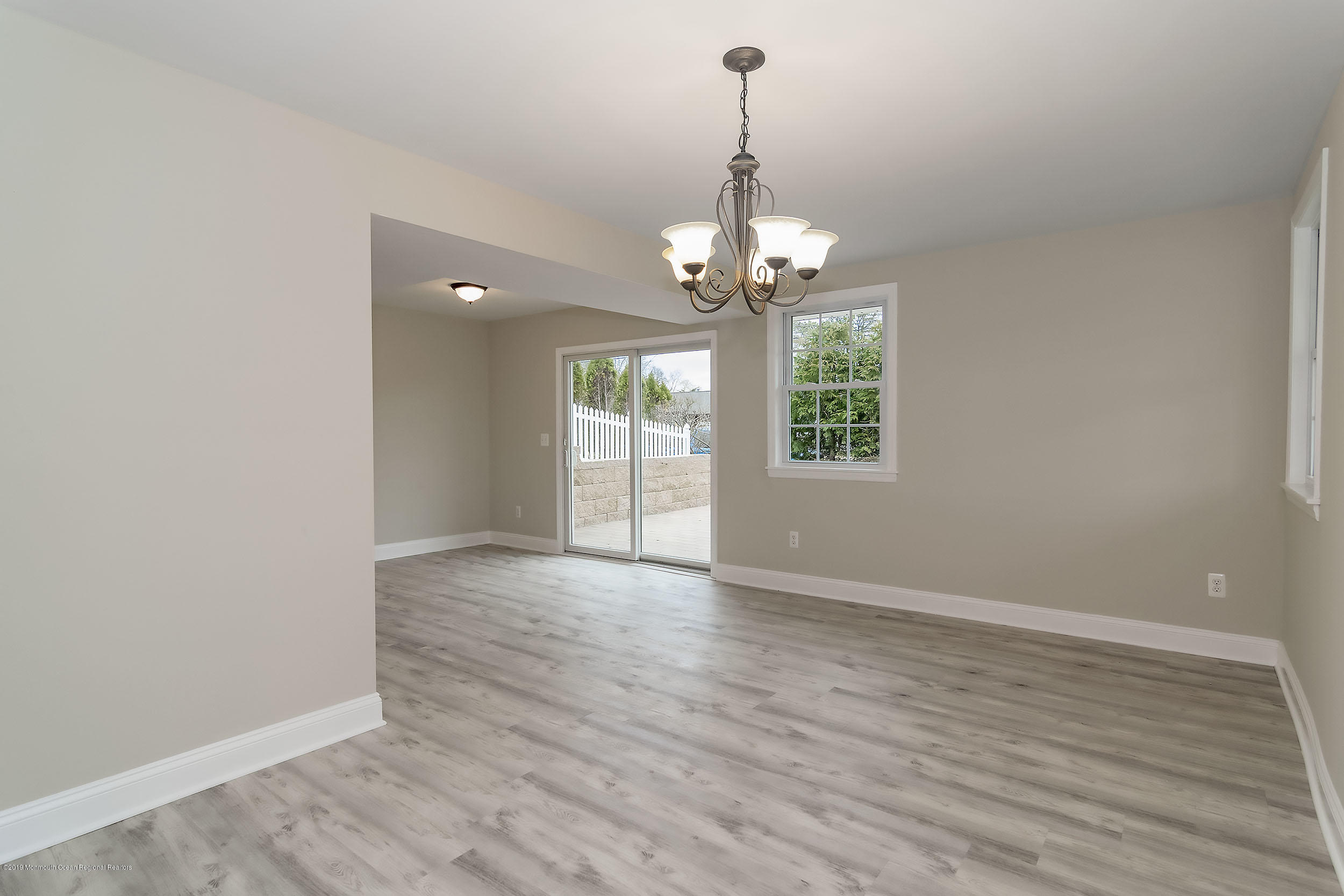 1521 Treeneedle Road Point Pleasant, NJ 08742 - Photo 16 of 33 an empty room with wooden floor chandelier and windows