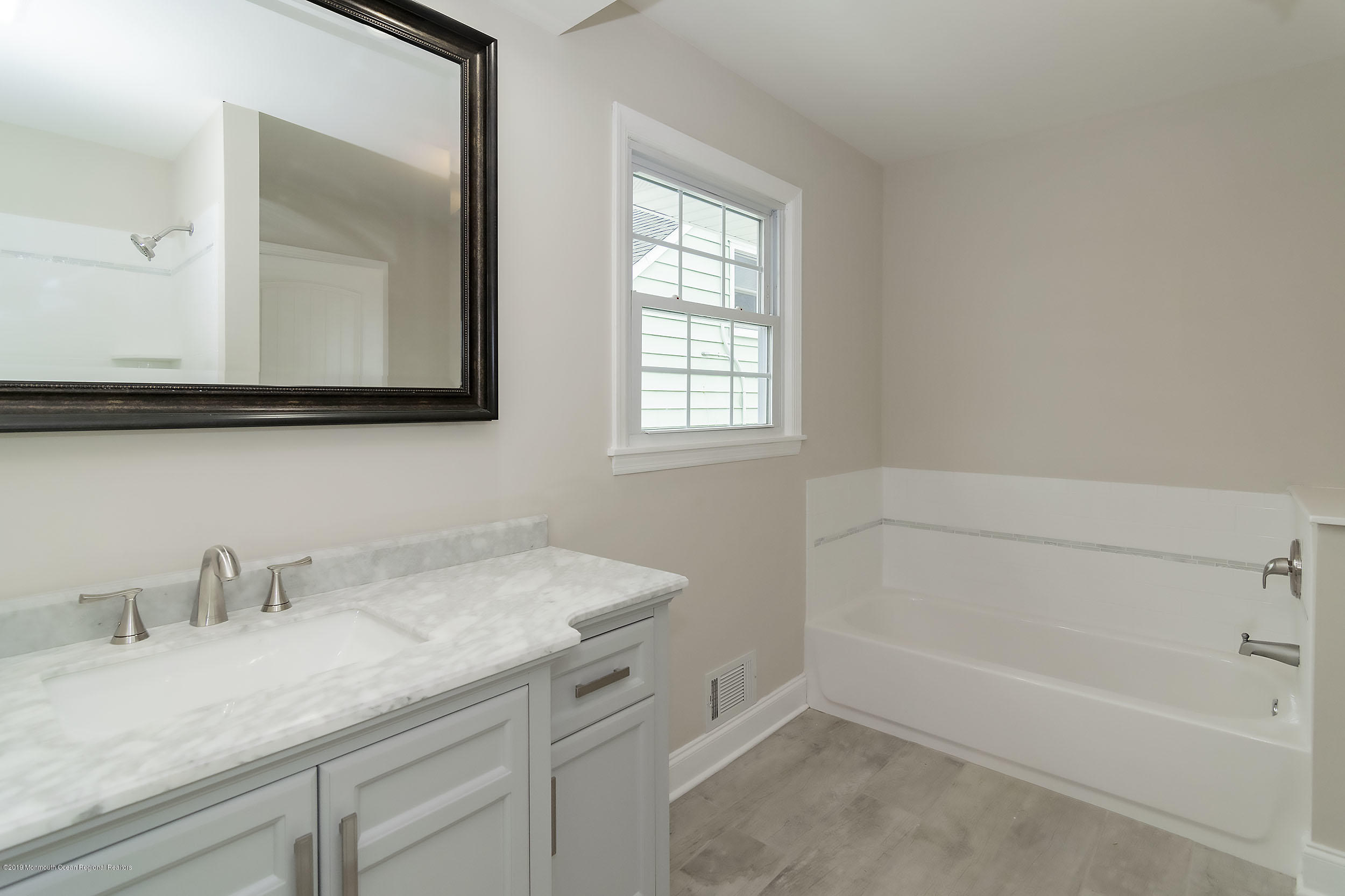 1521 Treeneedle Road Point Pleasant, NJ 08742 - Photo 23 of 33 a bathroom with a granite countertop sink mirror and vanity