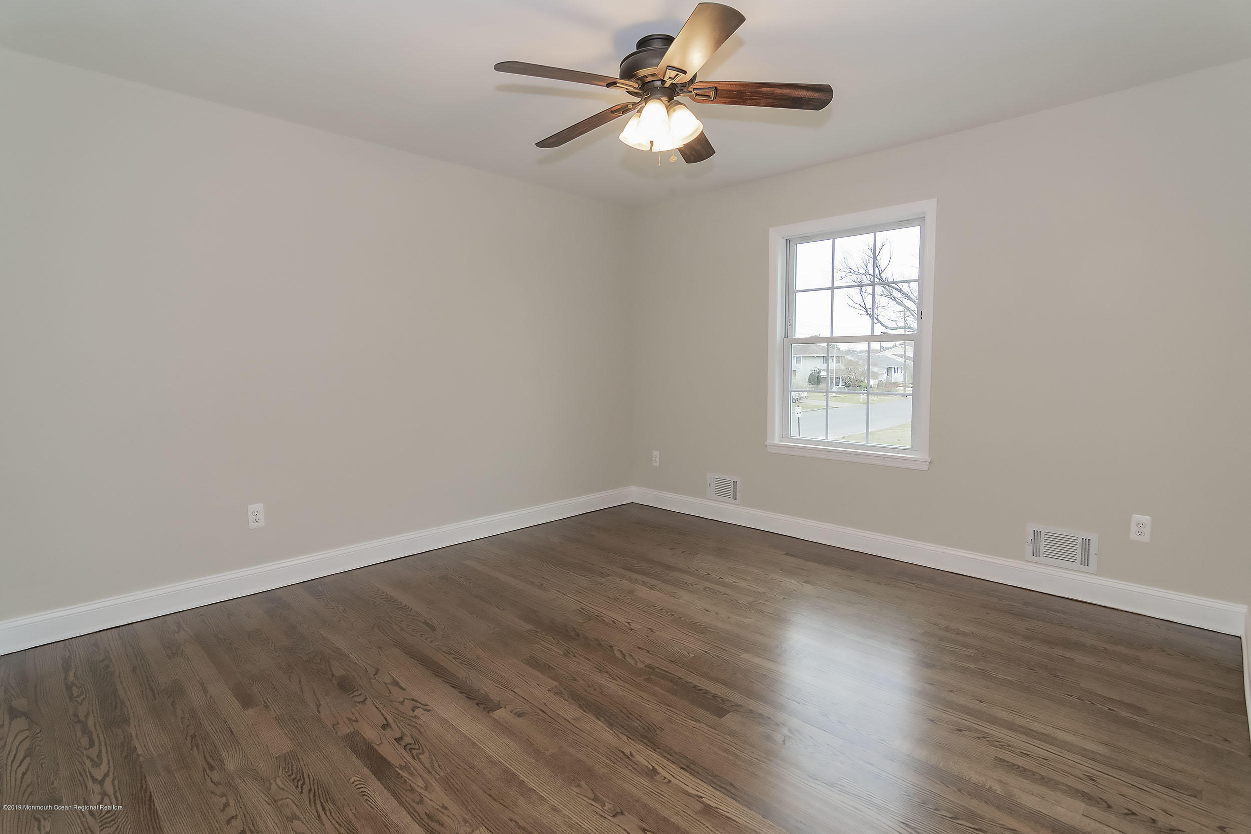 1521 Treeneedle Road Point Pleasant, NJ 08742 - Photo 26 of 33 an empty room with wooden floor fan and windows