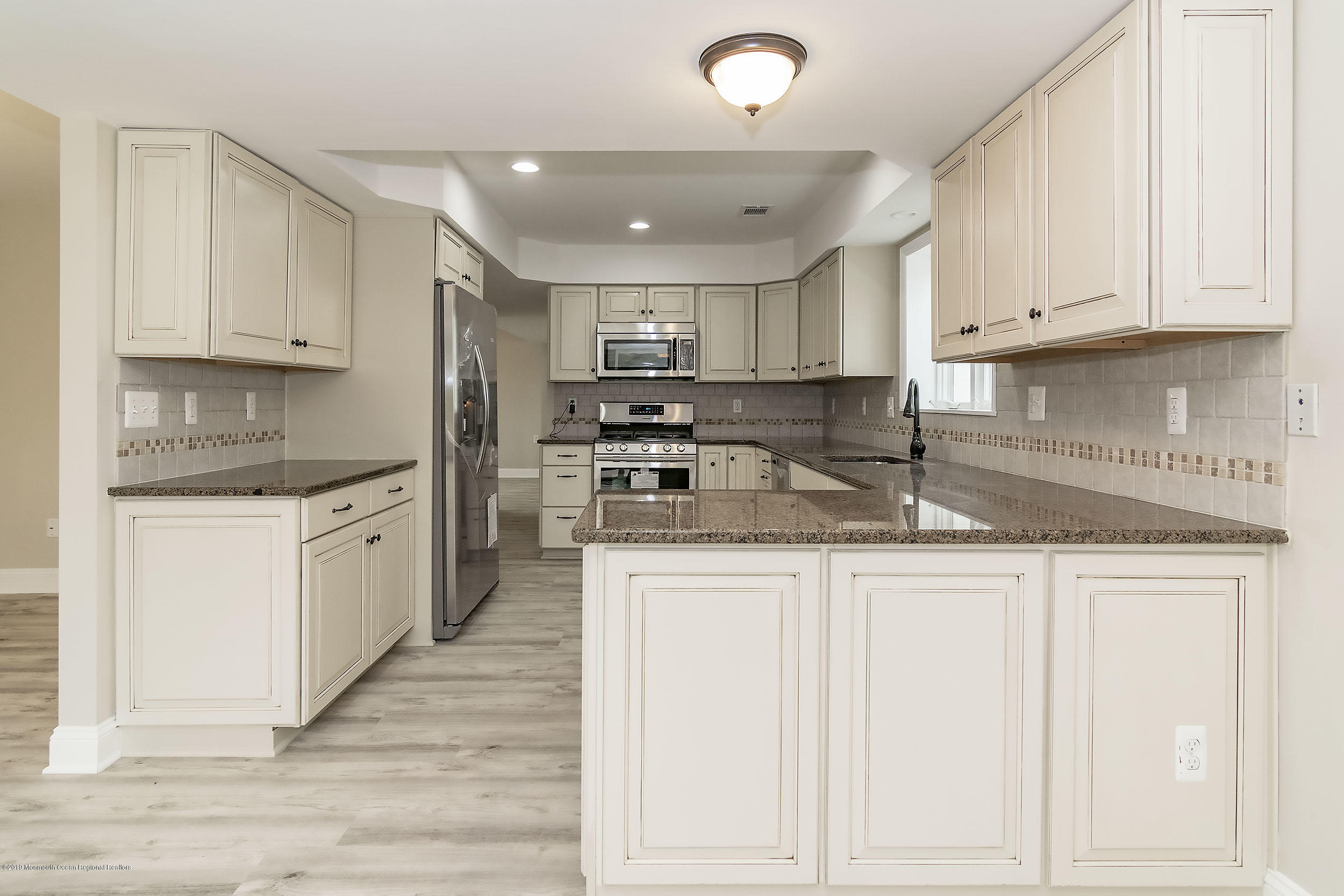 1521 Treeneedle Road Point Pleasant, NJ 08742 - Photo 3 of 33 a kitchen with granite countertop white cabinets and white appliances