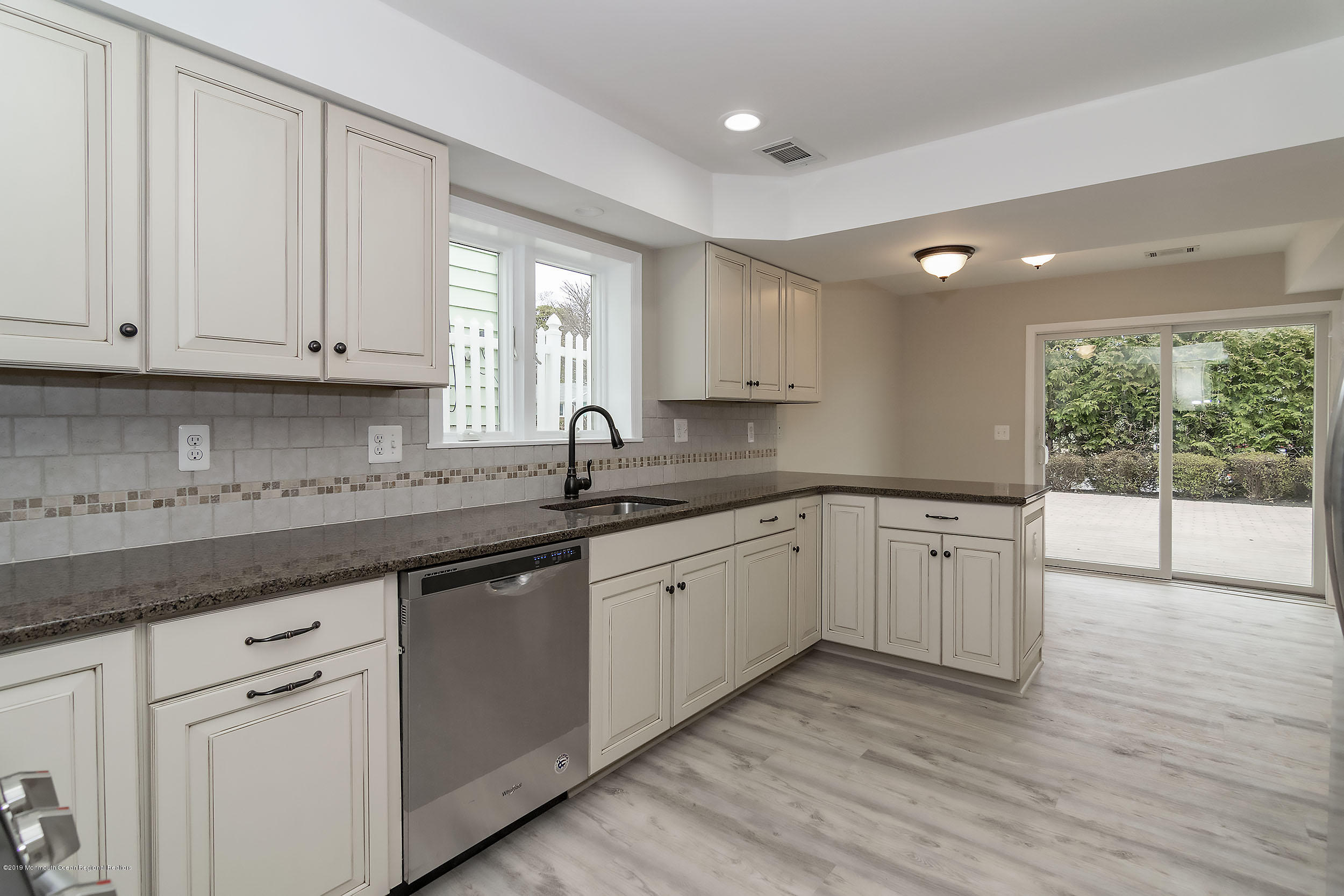 1521 Treeneedle Road Point Pleasant, NJ 08742 - Photo 4 of 33 a kitchen with granite countertop white cabinets white appliances with a sink and dishwasher with wooden floor
